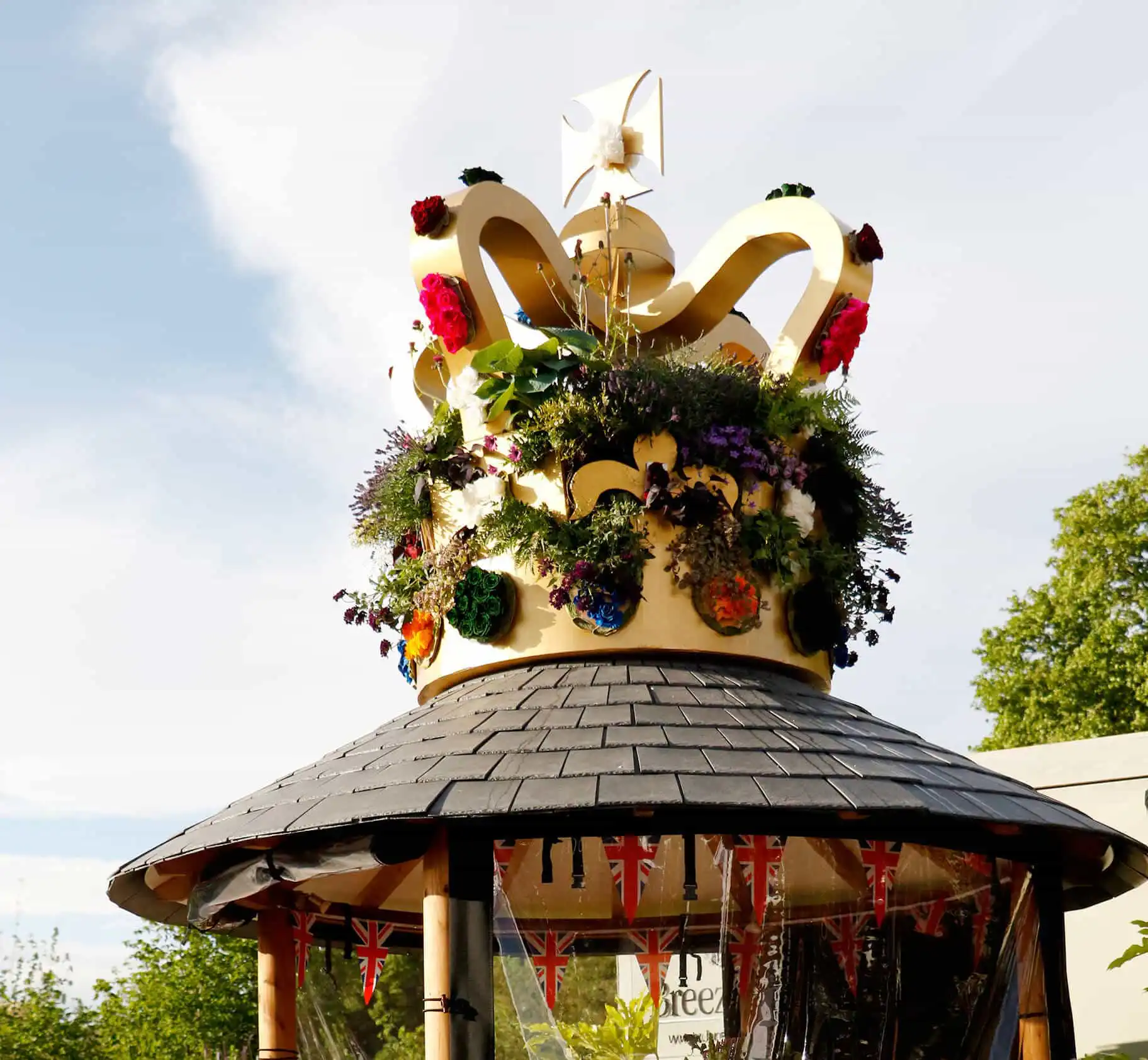 Giant planted crown on the roof of a Breeze House garden building at Chelsea Flower Show 2022