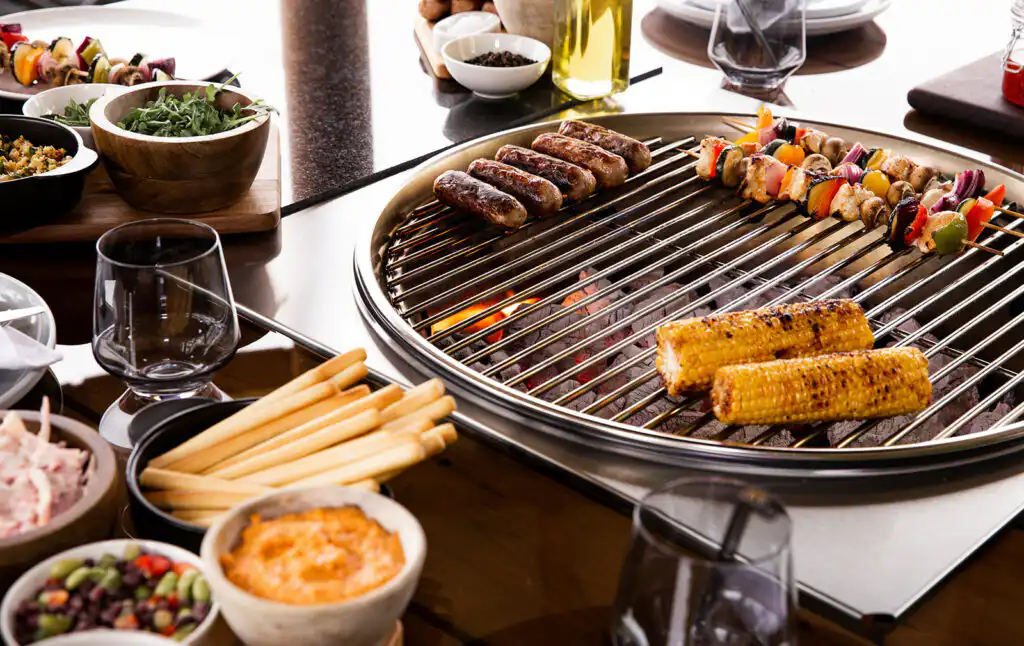 Sausages, kebabs and corn on the cob cooking on the Breeze House grill