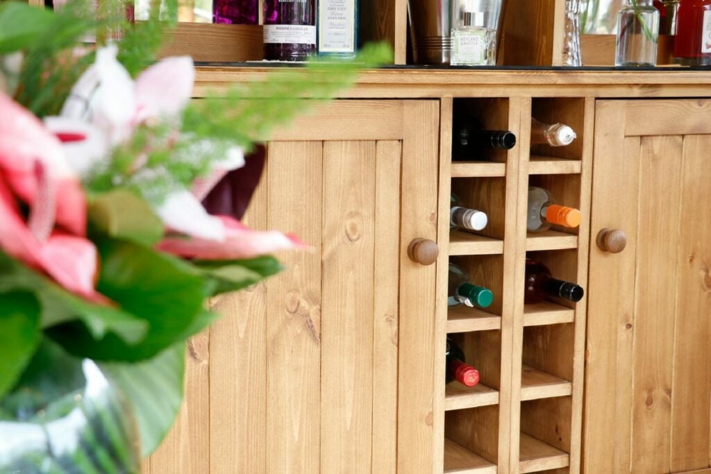 close view of breeze house wine cabinet containing wine bottles with flowers