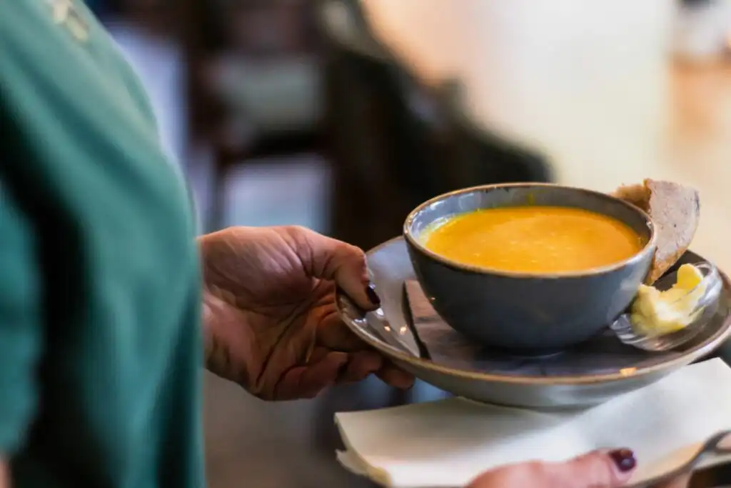 Person holding a bowl of soup