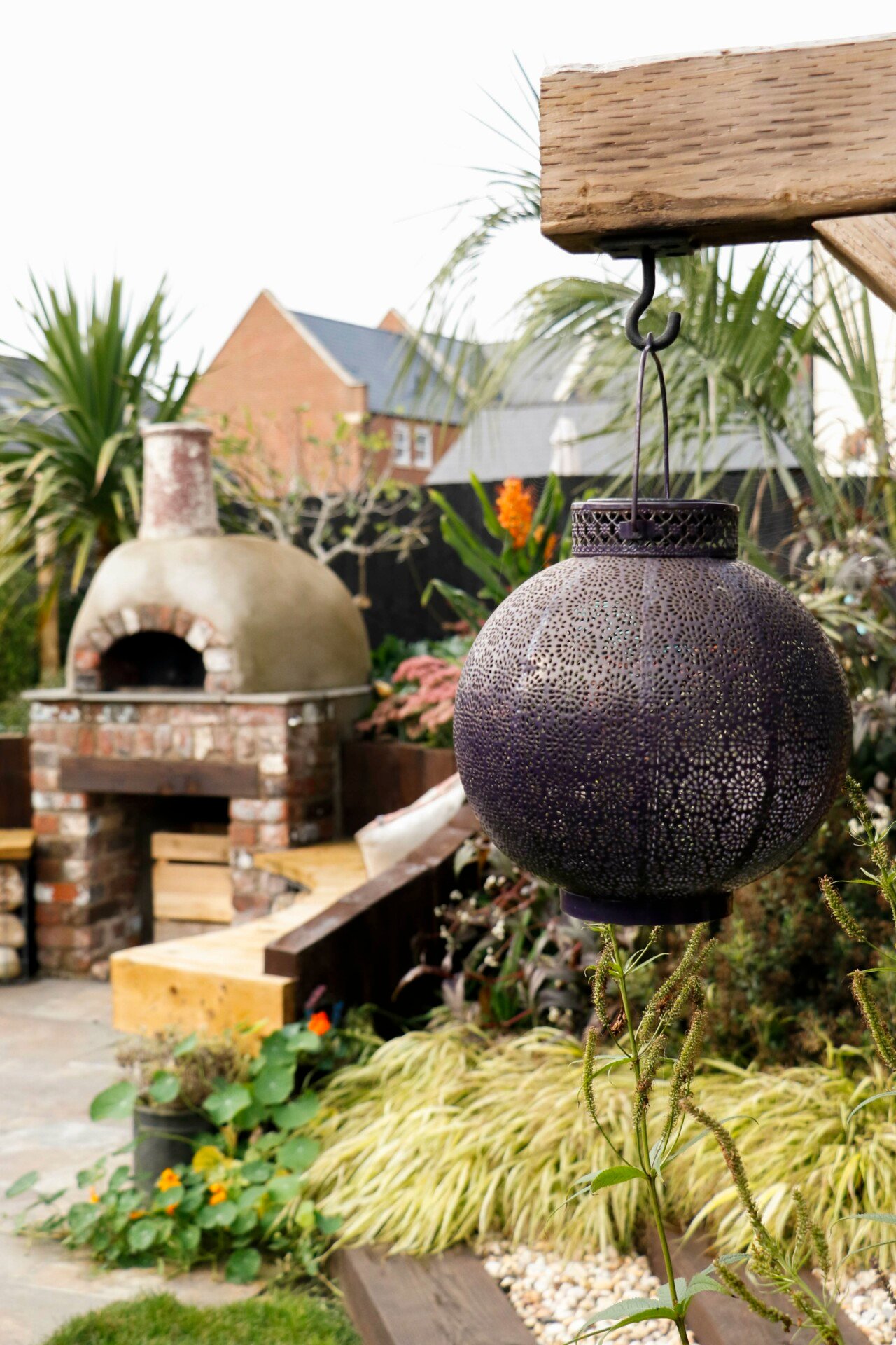 Hanging ornament in garden, with a brick pizza oven visible in background