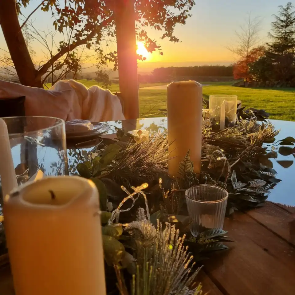 table with candles and flower decorations inside a breeze house gazebo