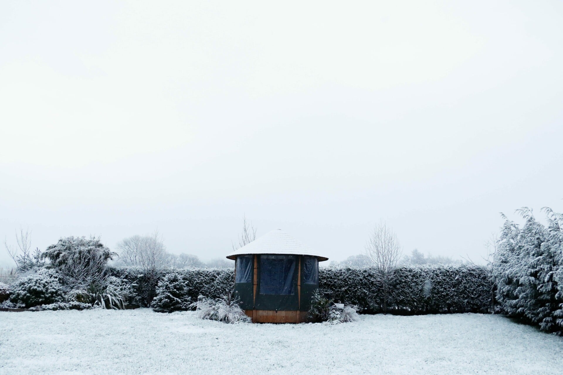 breeze house gazebo in garden covered in snow with closed canvas panels