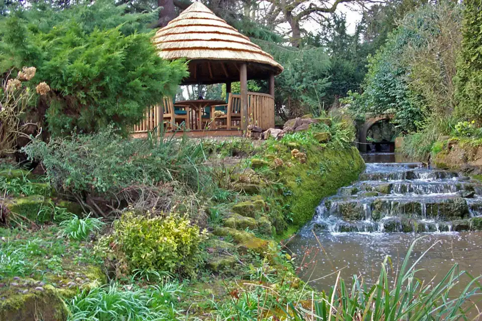 breeze house Amanzi gazebo in garden with small river and water fall feature