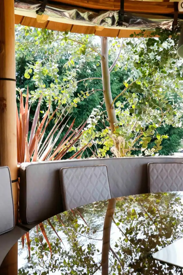 breeze house grill building with plants and flowers seen through open sides