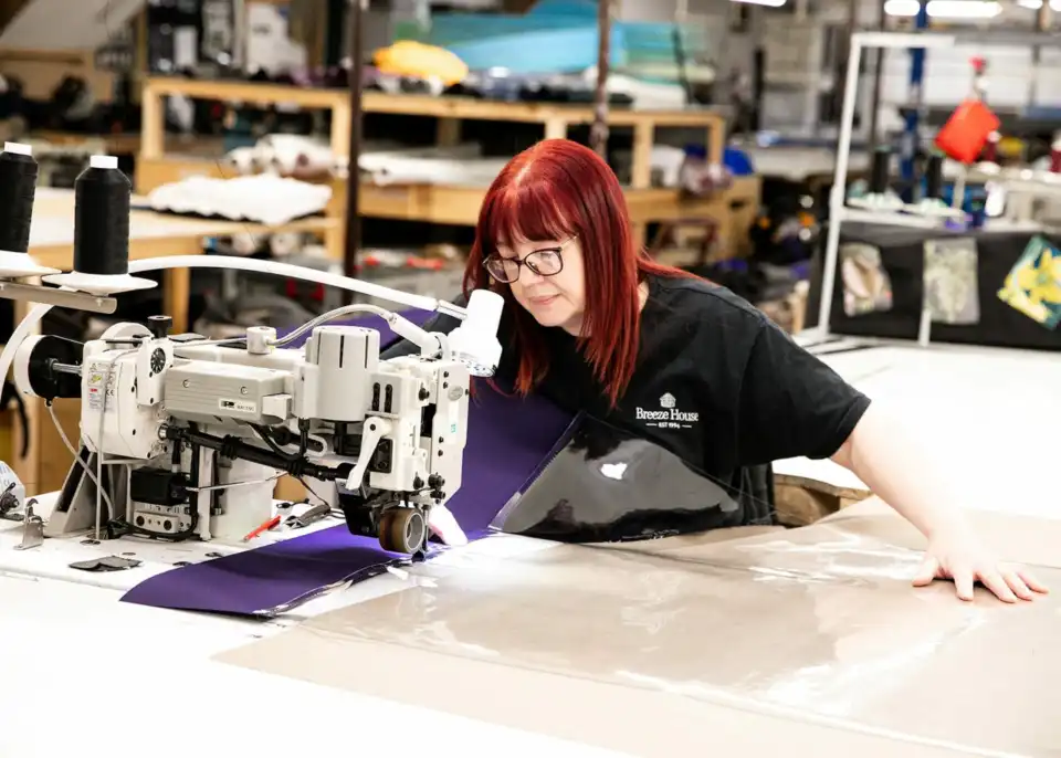 female breeze house factory worker using machinery working with fabrics