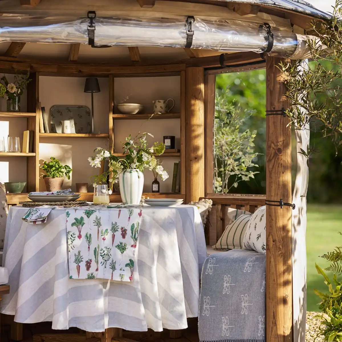 covered dining area and seating with bookcase inside breeze house building created in collaboration with sophie allport