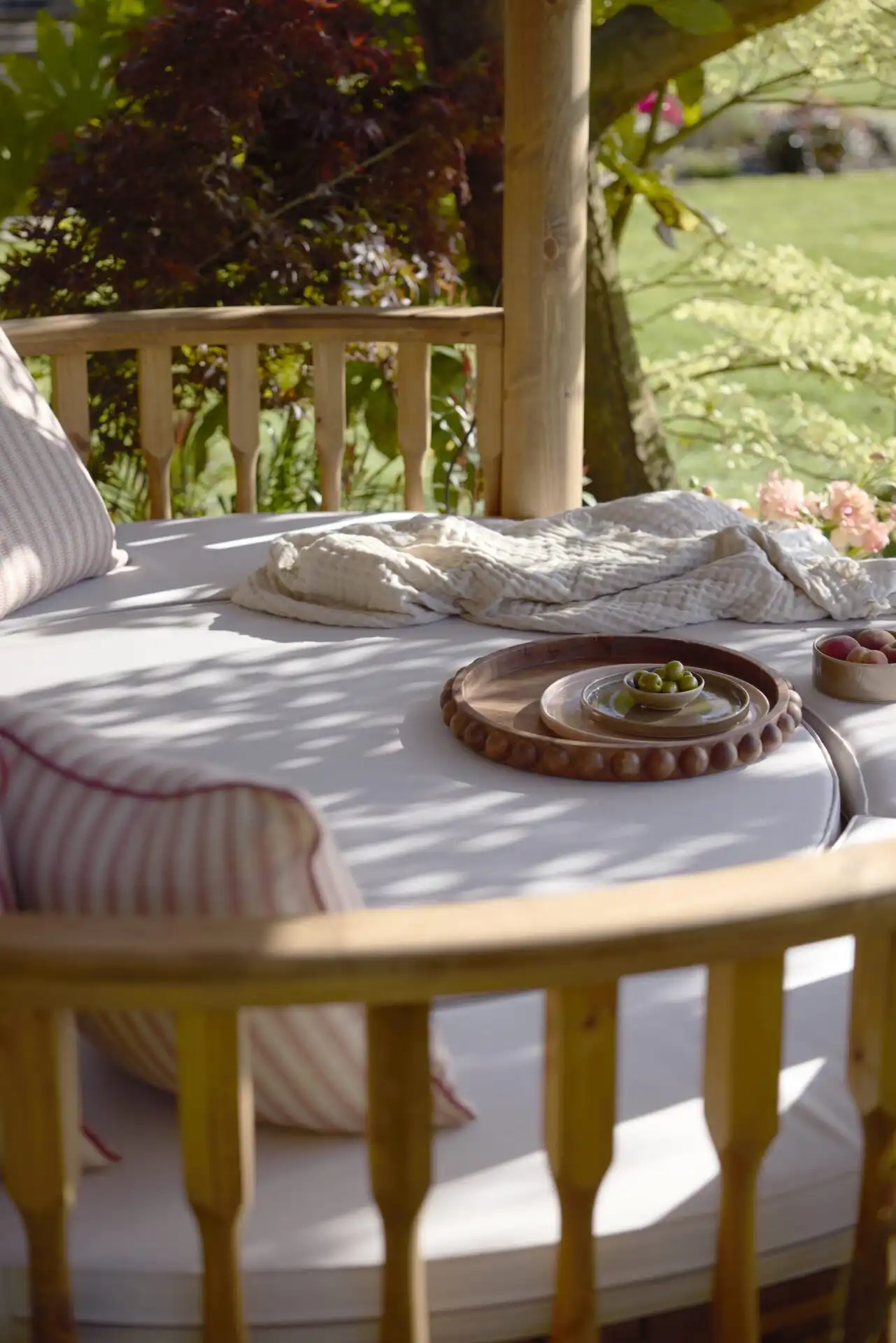 day bed cushions inside RHS breeze house a plate of fruit and olives with a blanket are placed on the bed
