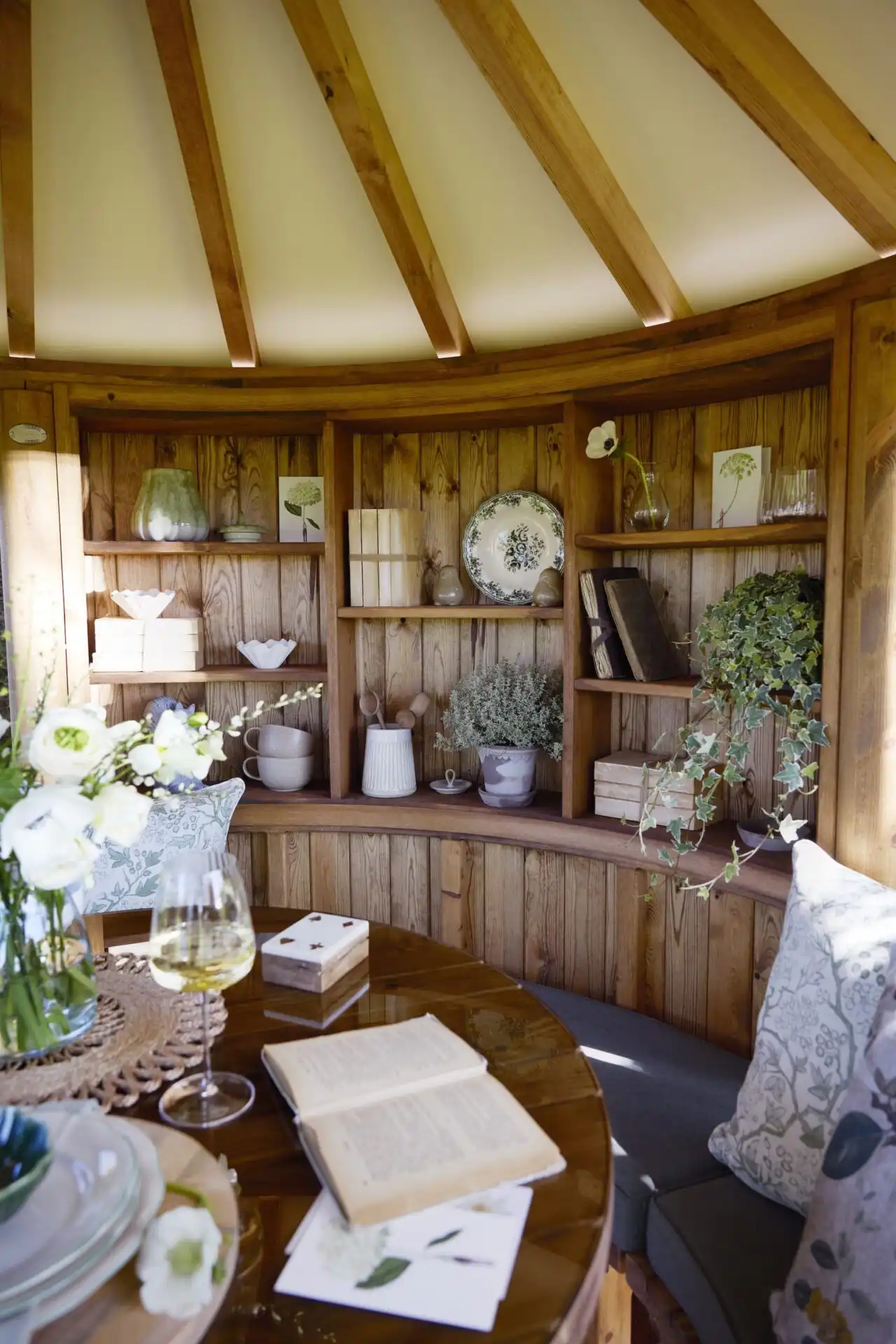 reading nook wall containing books and ornaments inside RHS breeze house