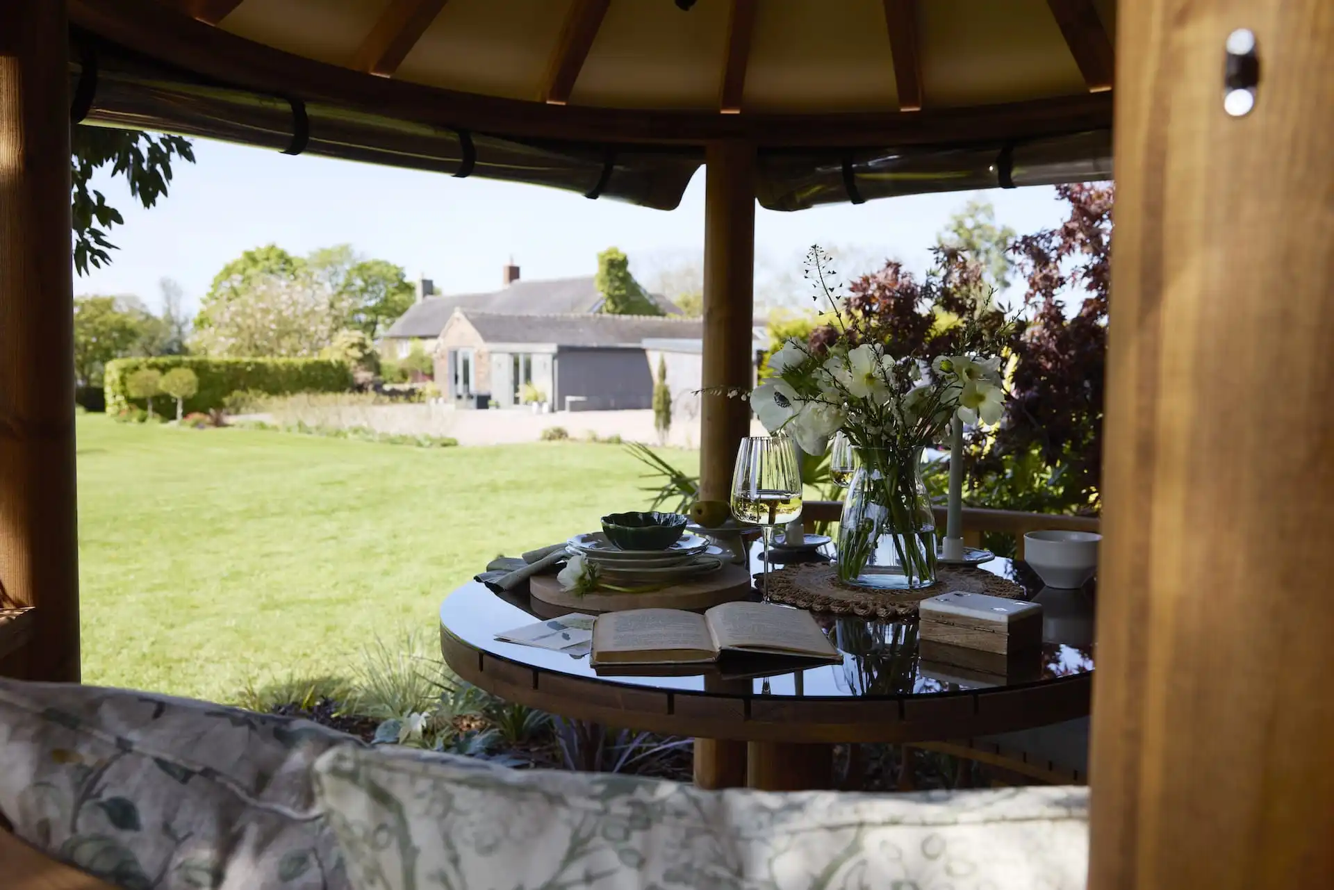 view through side panel of RHS breeze house open book seen on dining table with flowers
